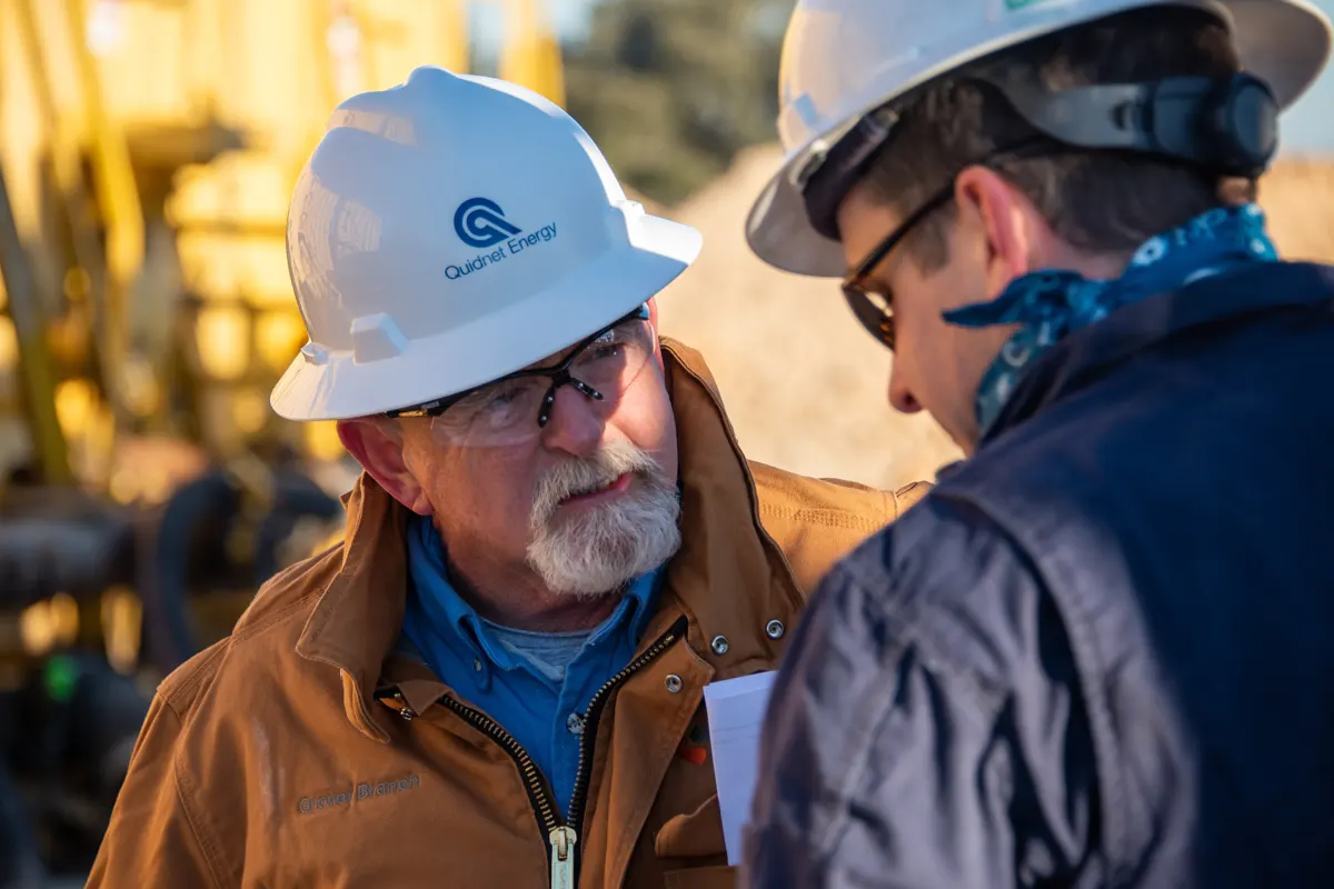 Two people in hard hats onsite at a Quidnet site